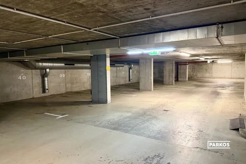 Überdachter Tiefgaragenbereich mit markierten Stellplätzen 36 bis 40, Betonpfeilern und Lüftungsrohr.