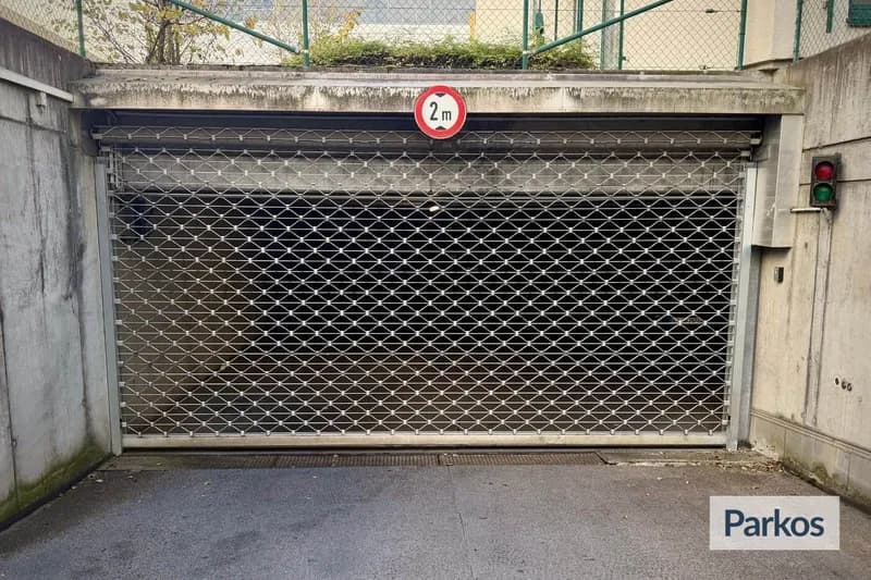 Geschlossenes Rollgitter vor Tiefgaragenausfahrt mit 2 m Schild und grüner Ampel.