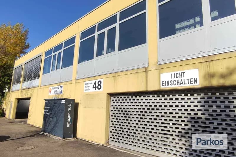 Gelbes zweigeschossiges Gebäude mit geschlossener Rolltorgarage, Amazon-Hub-Schrank und der Hausnummer 48.