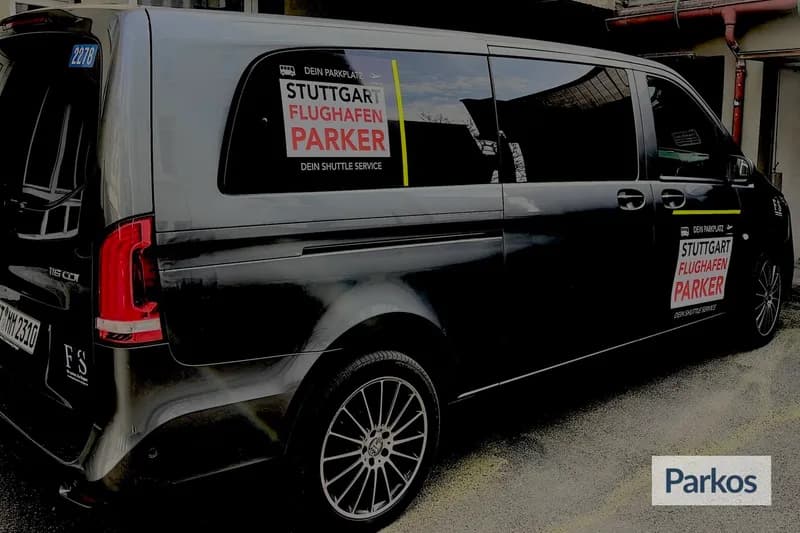 Dunkler Transferbus mit Aufschrift STUTTGART FLUGHAFEN PARKER seitlich geparkt.