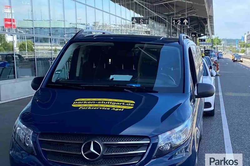 Dunkelblauer Mercedes Van mit Aufkleber parken-stuttgart.de Parkservice Agel vor Terminalfenstern am Flughafen Stuttgart.